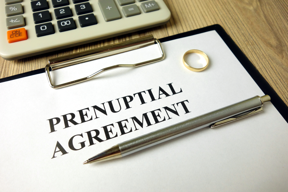 prenuptial agreement with pen calculator and wedding ring