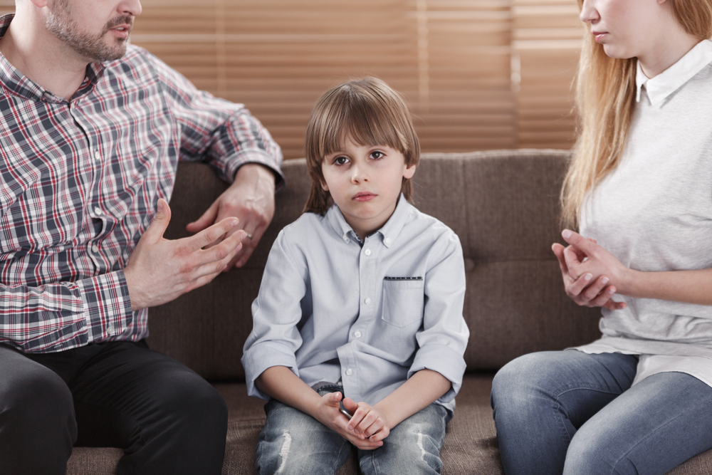 sad child and his parents arguing. Problem in the family